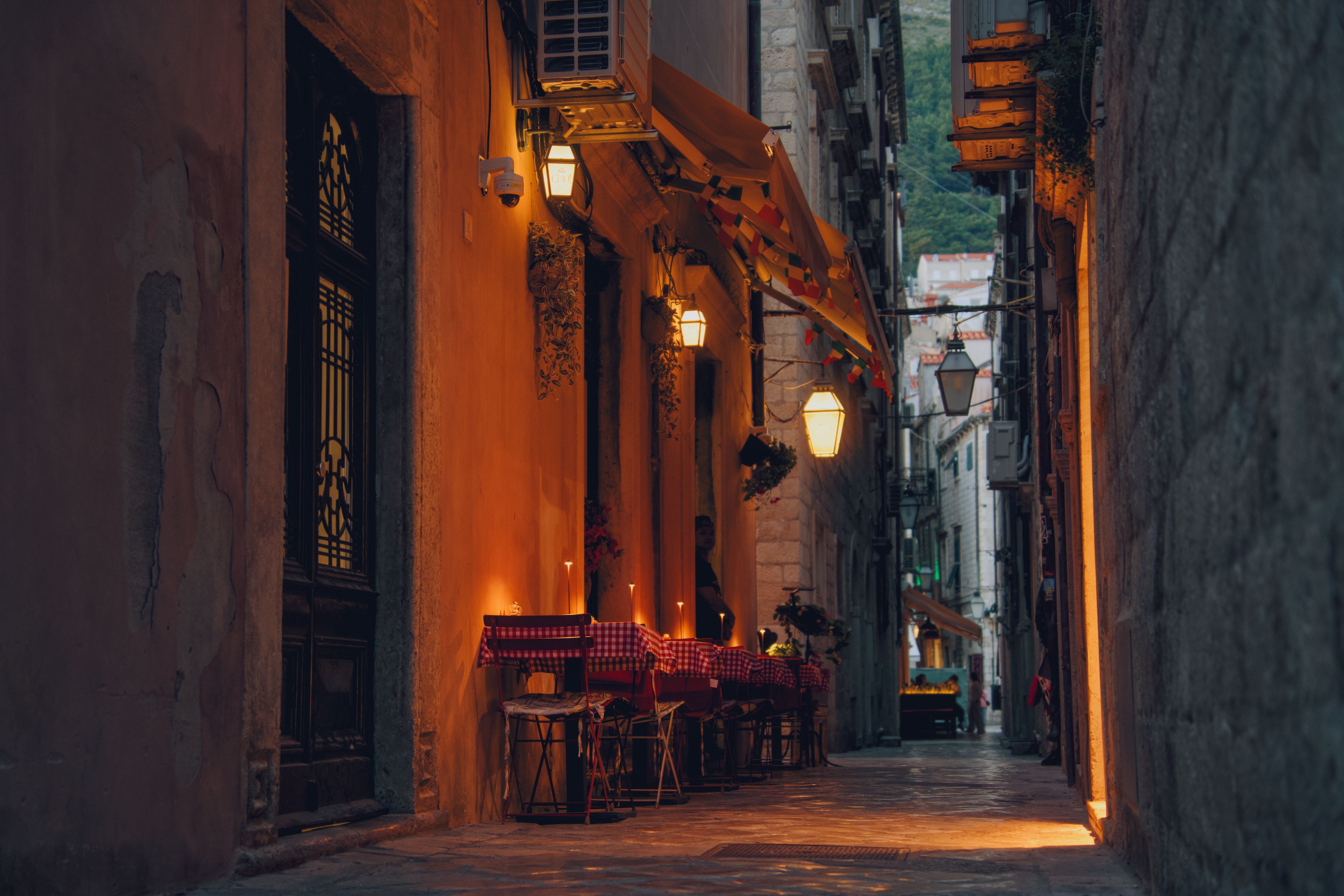 Candlelit outdoor dining on a narrow Dubrovnik street, ideal for a romantic weekend getaway.