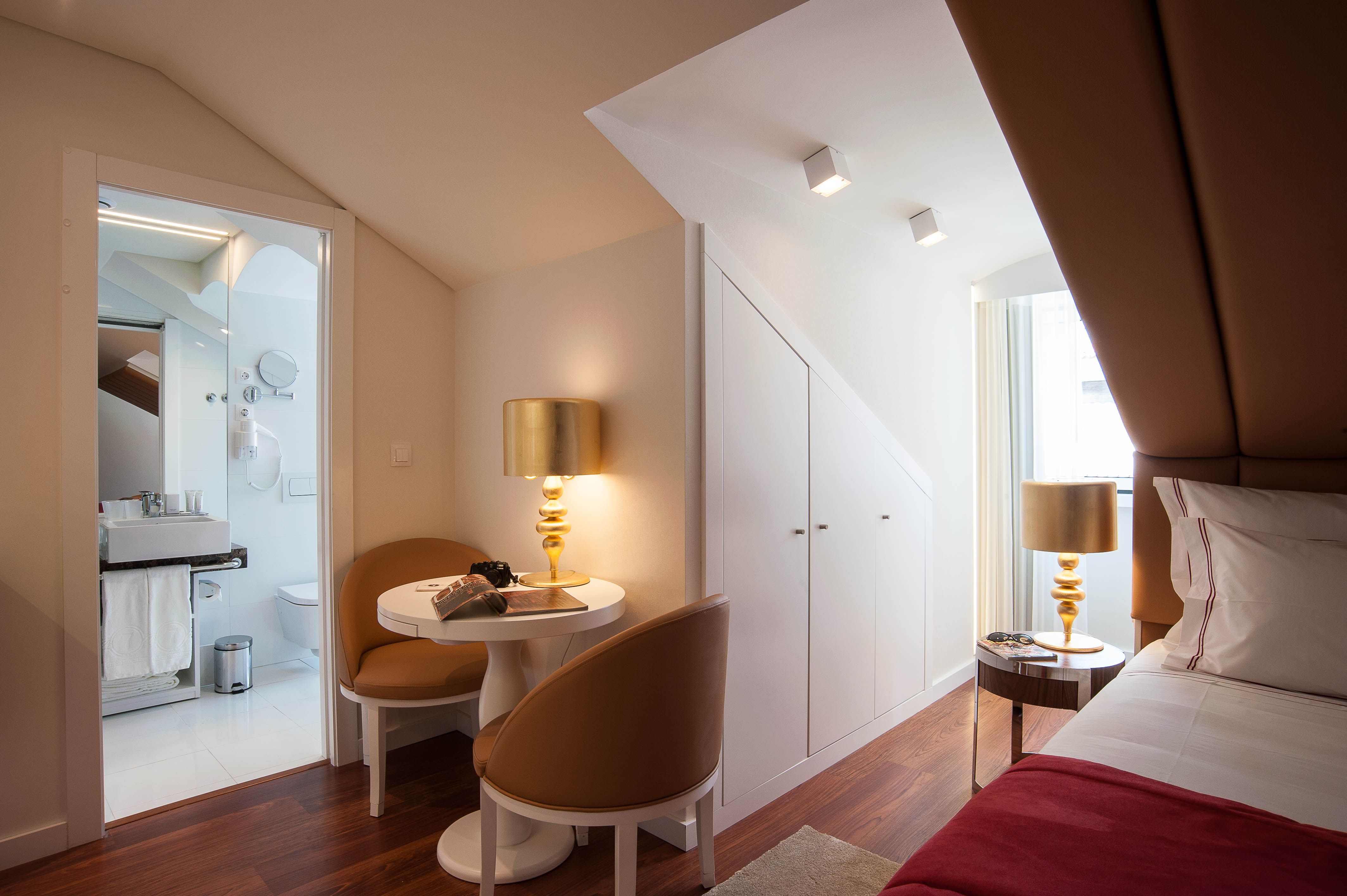 Elegant boutique hotel room in Lisbon with modern furnishings and warm lighting.